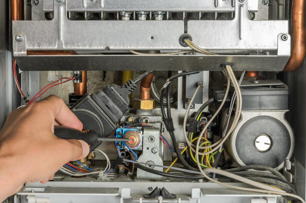 Technician servicing the internal components of a boiler
