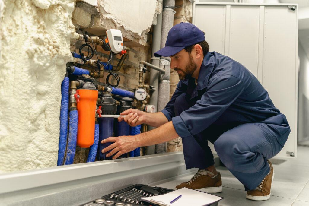 Professional plumber repairing water supply system at home uses an adjustable wrench